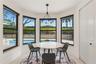 Bay window featuring floor-to-ceiling windows with black frames, tile flooring, and a multi-arm modern chandelier
