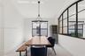 Black metal-framed glass partition, modern multi-globe chandelier, built-in wine refrigerator, and tile flooring