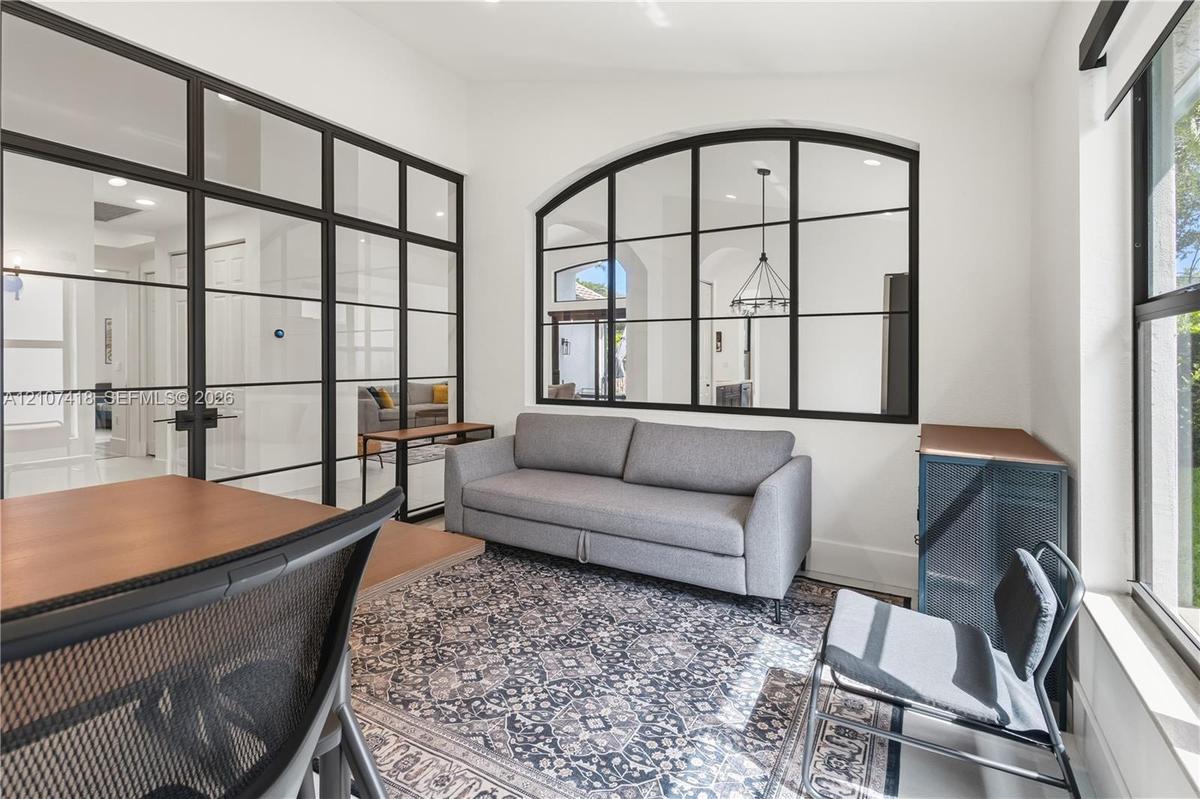 Interior space featuring floor-to-ceiling metal-framed glass partitions and a large arched metal-framed glass window