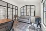 Interior space featuring floor-to-ceiling metal-framed glass partitions and a large arched metal-framed glass window