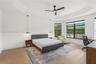 Tray ceiling, wood-finish flooring, matte black ceiling fan, and black-framed windows