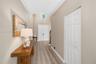 Entryway featuring double-door entry, vaulted ceilings, high-placed window, wood-finish flooring, and a multi-panel bi-fold closet door