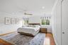 Wood-finish flooring, ceiling fan with natural-tone blades, white board-and-batten wall paneling, and recessed lighting