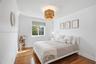 Room featuring wood-finish flooring, crown molding, and a drum-style ceiling light fixture