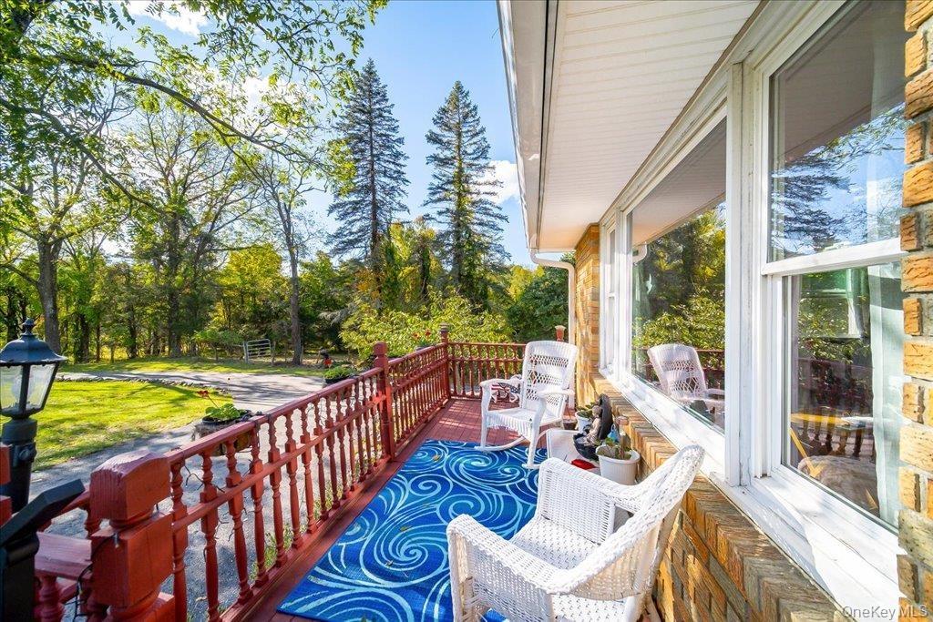 This lovely sunny front deck overlooks the circular drive and expansive grounds,