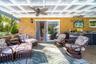 Entertain out in this covered side-patio featuring outdoor -kitchen cabinetry overlooking the pond and expansive grounds!