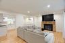 Living area featuring light wood-finish flooring, recessed lighting, and a floor-to-ceiling river stone fireplace