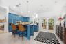 Kitchen featuring custom blue cabinetry, a center island with stone countertops, recessed lighting, and dual glass-paned doors