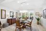 Tray ceiling with recessed lighting, tile flooring, plantation shutters, and a suspended contemporary chandelier
