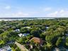 Aerial perspective featuring a terracotta tile roof, mature canopy trees, and waterfront proximity