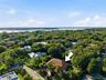 Aerial perspective featuring a tile roof, screened lanai enclosure, and mature landscaping
