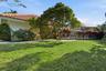Backyard space featuring a tiled roof, screened enclosure, and mature landscaping