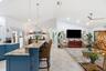 Vaulted ceilings featuring recessed lighting, a kitchen island with stone countertops, blue cabinetry, tile flooring, and a ceiling fan