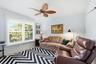 Interior space featuring a palm-leaf blade ceiling fan and double-pane windows with plantation-style shutters