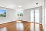 Room featuring wood-finish flooring, recessed lighting, double French doors, and windows with exterior greenery