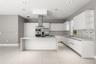 Kitchen featuring flat-panel cabinetry, a central island with a waterfall countertop, stainless steel appliances, a linear-patterned backsplash, and l