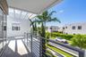 Covered outdoor terrace featuring a concrete floor, horizontal metal railing, and a slatted pergola ceiling