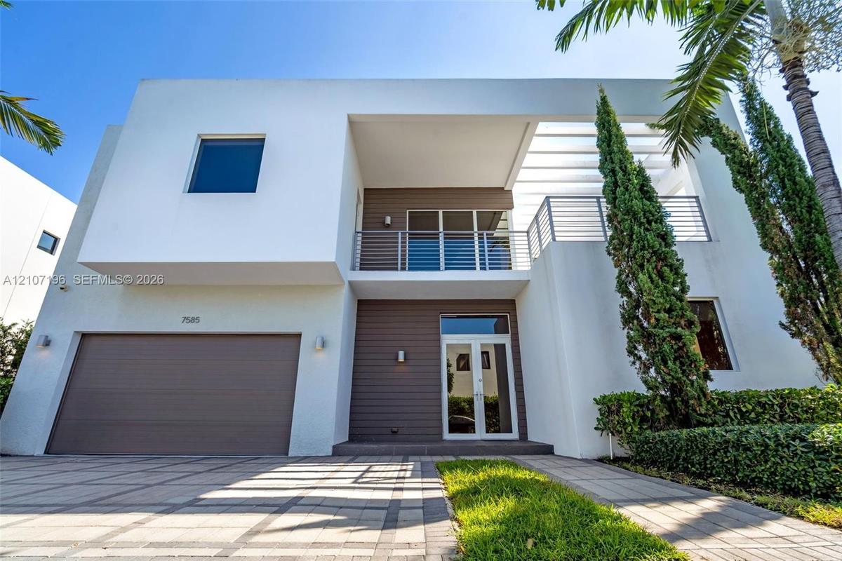 Modern two-story architectural exterior featuring smooth white stucco finish, horizontal wood-panel siding, upper-level balcony with metal railing, an