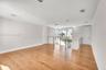 Open-concept interior featuring wood-finish flooring, recessed lighting, and a metal-rail staircase
