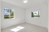 Neutral-toned tile flooring, flush-mount ceiling lighting, and dual windows with built-in roller shades