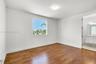 Room featuring wood-finish flooring, a large window, neutral wall paint, and recessed ceiling lighting