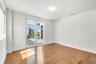 Interior space featuring wood-finish flooring, white walls, and glass-paned French doors opening to an exterior terrace