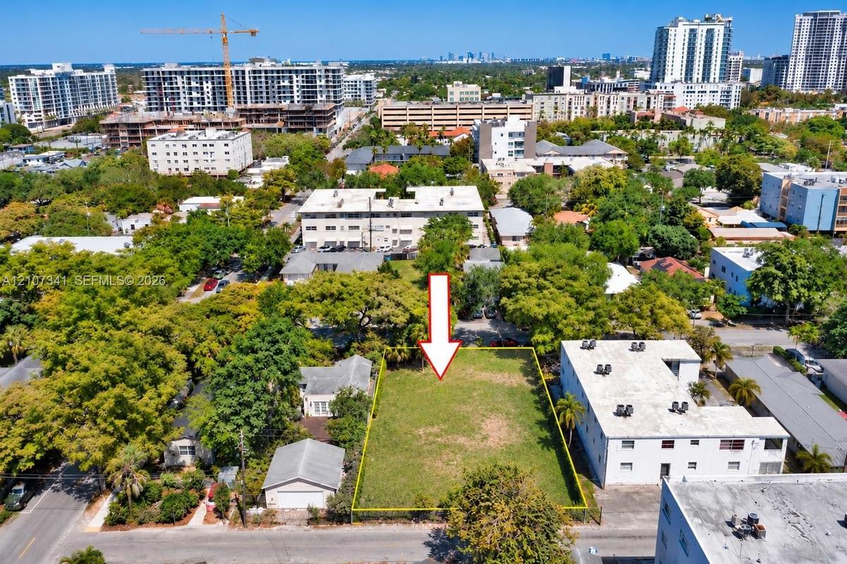 Vacant rectangular lot featuring level topography, perimeter fencing, and mature canopy trees