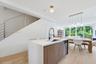 Kitchen island featuring a stone countertop, wood-finish cabinetry, and a gooseneck faucet
