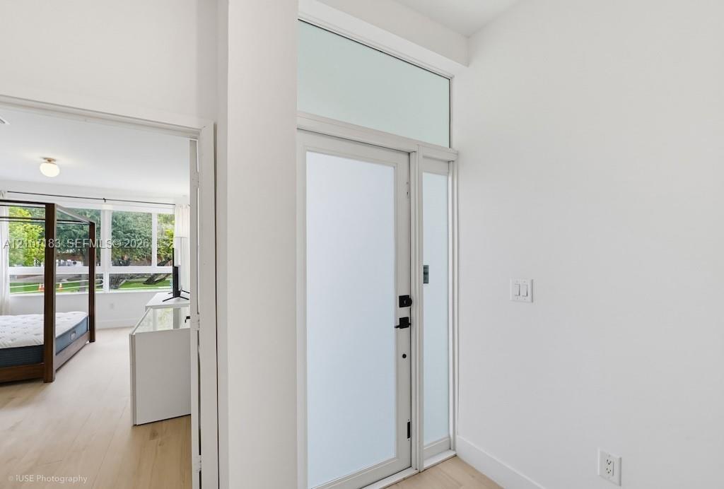 Entryway featuring a glass-panel door with frosted finish, transom window, and wood-finish flooring