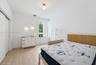 Bedroom featuring wood-finish flooring, a large window, sliding-door closet, and modern ceiling lighting