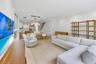 Open-concept living space featuring wood-finish flooring, recessed lighting, and a modern kitchen with flat-panel cabinetry and a multi-pendant light 