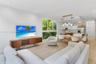 Open-concept living space featuring wood-finish flooring, recessed lighting, multi-pane floor-to-ceiling windows, and a kitchen equipped with cabinetr