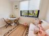 Open bonus area adjacent to the kitchen and near the second bedroom entrance, featuring a sleeper sofa for additional guests.