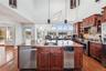Kitchen with sink, an island with sink, pendant lighting, stainless steel appliances, and hardwood / wood-style floors