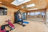 Exercise room featuring a baseboard radiator, a skylight, and light hardwood / wood-style floors