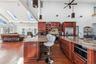 Kitchen featuring sink, a skylight, stainless steel appliances, and light stone countertops
