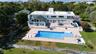 Rear view of property with a lawn, a fenced backyard, an outdoor pool, a chimney, and a patio area