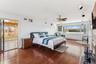 Bedroom with ceiling fan, wood-type flooring, and a baseboard heating unit