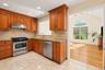 Kitchen includes stainless steel appliances and stone backsplash