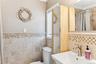 Bathroom featuring sink, tile walls, toilet, crown molding, and a shower with shower curtain