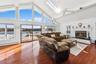 Living room with a water view, high vaulted ceiling, dark hardwood / wood-style flooring, and baseboard heating