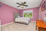 Window with roller shades, ceiling fan with integrated lighting, wall-to-wall carpeting