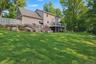 Expansive green lawn, multi-level decking, natural rock landscaping.