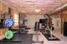Unfinished basement featuring exposed insulation, concrete flooring, and an egress window and sliders out to the yard