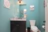 Bathroom featuring a dark wood-finish vanity with a light speckled countertop, dual-handle faucet, and a wall-mounted mirror