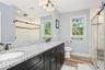 Dual vanity with speckled countertop and dark wood-finish cabinetry