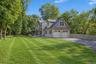 Two-story property featuring a covered porch, attached two-car garage, dormer windows, and a paved driveway