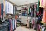 Custom closet system featuring multiple hanging rods, integrated shelving, and built-in drawers