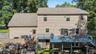 Large elevated rear deck with surrounding trees and a stone retaining wall