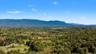 Expansive wooded landscape with distant mountain ranges under a clear sky